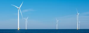 A mesmerizing view of a row of wind turbines gracefully spinning in the vast ocean, capturing the