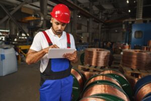 African american male manager in electric cable warehouse holding digital tablet