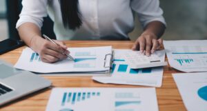Businesswomen analyzing investment graph and discussing plan in meeting room, investment concept