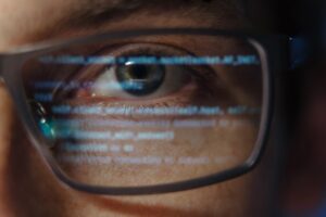 Close-up of programmer with code reflection
