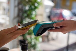 close up shot of person making a payment with mobile phone to device
