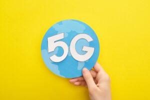 cropped view of woman holding globe with 5g lettering on yellow background