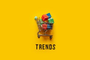 Ecommerce Retail Shopping trends concept. Word Trends and mini shopping cart with box on yellow