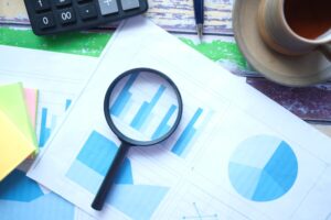 financial data and magnifying glass on blue .