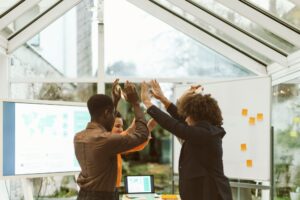 Group Startup Celebrates Success - High-Five Exchange in Office After Successful