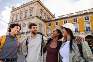 Happy tourists walking together in lisbon, portugal, visiting famous landmark