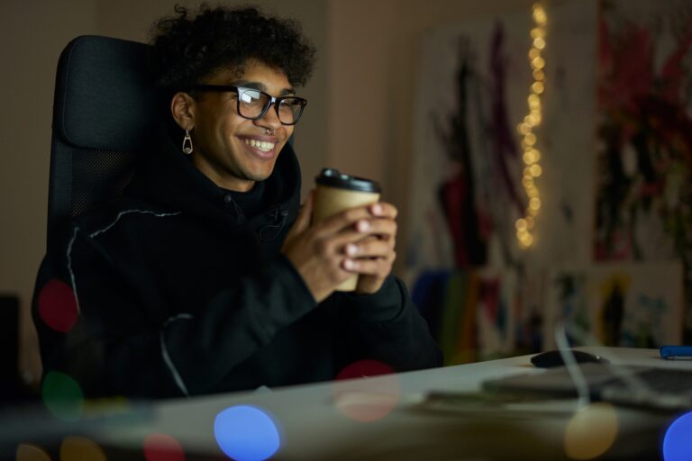 Leisure activities. Happy young guy with piercing wearing glasses holding disposable cup of coffee