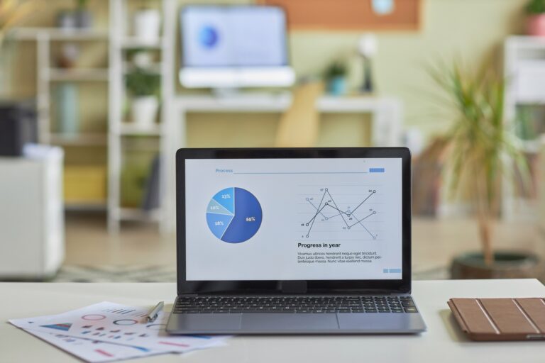 Open laptop computer with statistics data charts on screen on office workplace