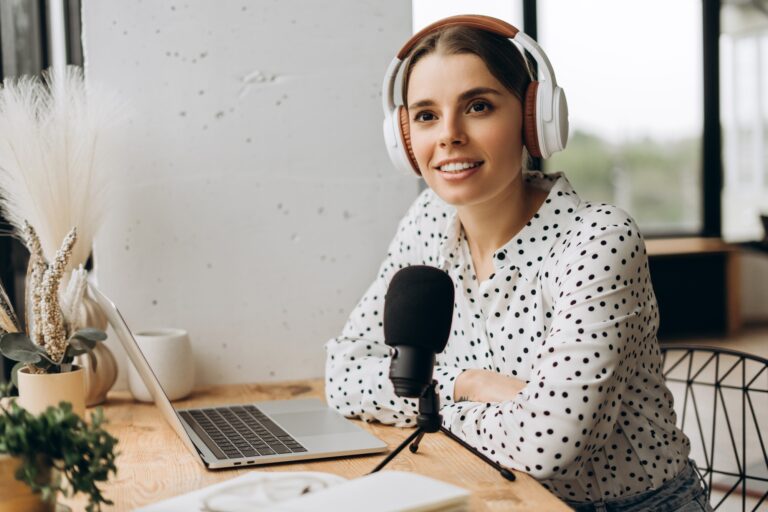 Podcaster woman recording audio podcast with microphone and headphones